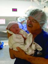 Dr. Leonard Brabson holds a baby he just delivered. Dr. Brabson has been an ob.gyn. since 1977.